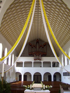 Foto vom festgeschm&uuml;ckten Kirchenraum zur Orgel hin gesehen