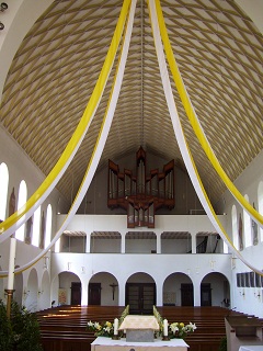 Foto vom festgeschmückten Kirchenraum zur Orgel hin gesehen