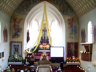 Foto vom Altarraum unserer Kirche im Kerzenlicht