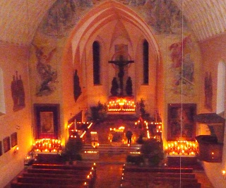 Foto der nur mit Kerzen erleuchteten Kirche