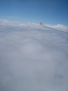 Foto aus dem Flieger über den Wolken